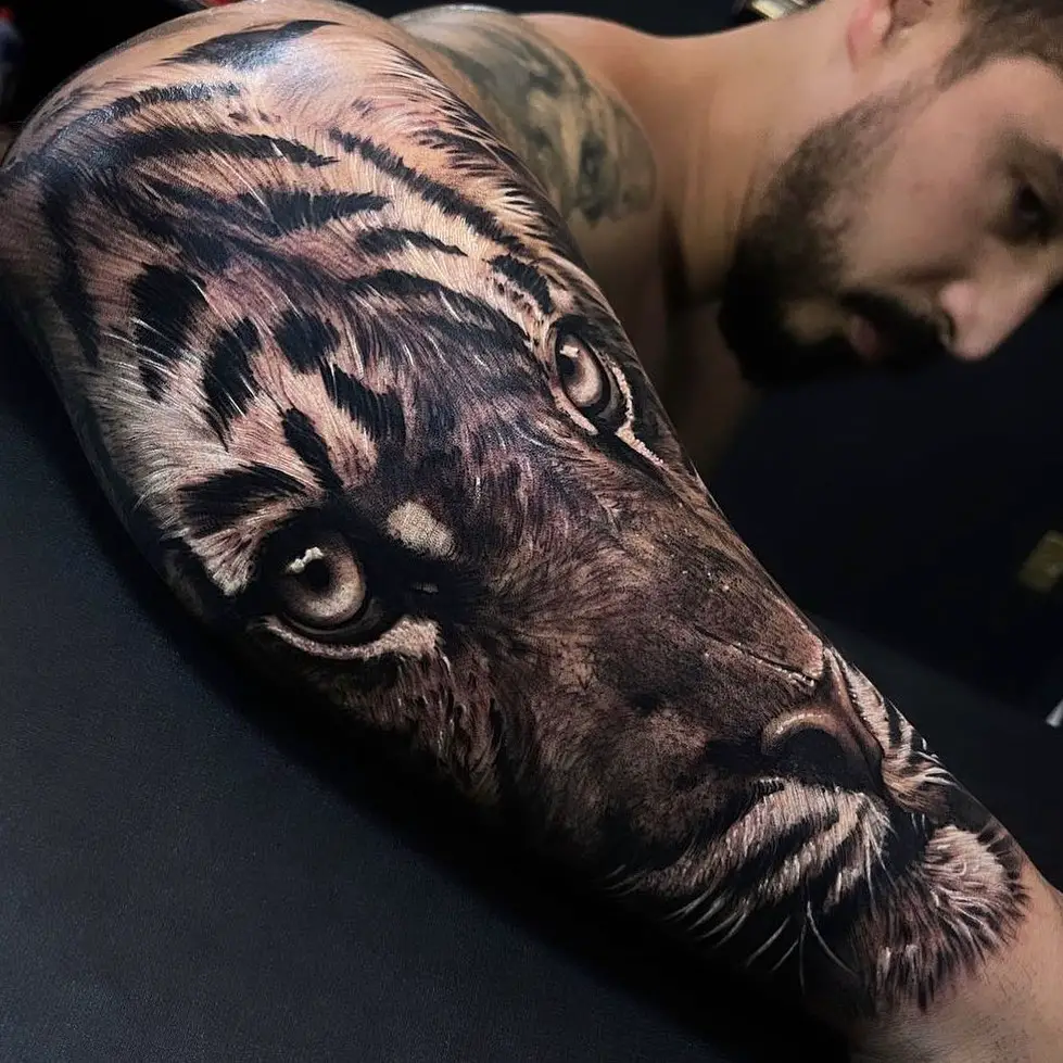 A realistic animal tattoos for men depicting a majestic tiger, showcasing the fur texture and expressive eyes.