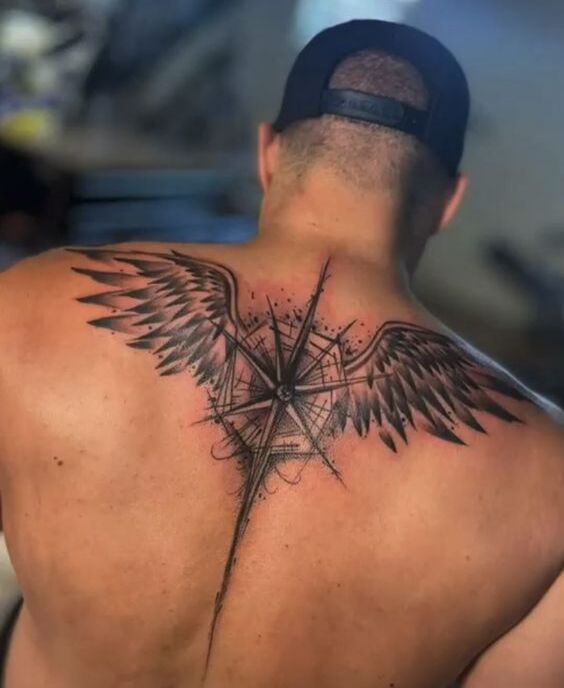 A tattoo with a compass and wings